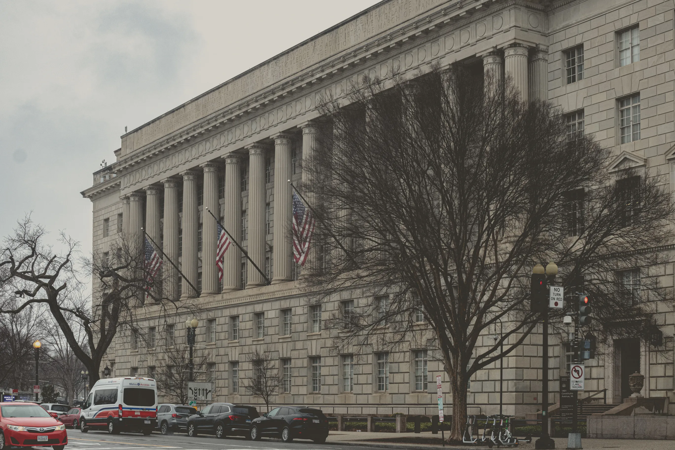 A neoclassical federal building with columns and American flags